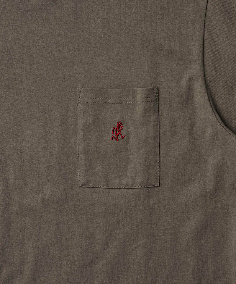 Close-up view of a Gramicci One Point Tee pocket in coyote brown on a light-tone background.