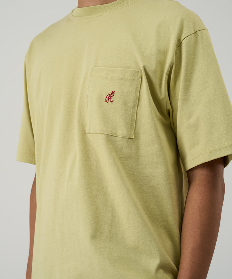 Model wearing a Gramicci lime One Point Tee with a small running man graphic against a light-tone background.