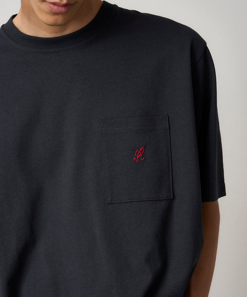 Model wearing a Gramicci vintage black One Point Tee with a small running man graphic against a light-tone background.