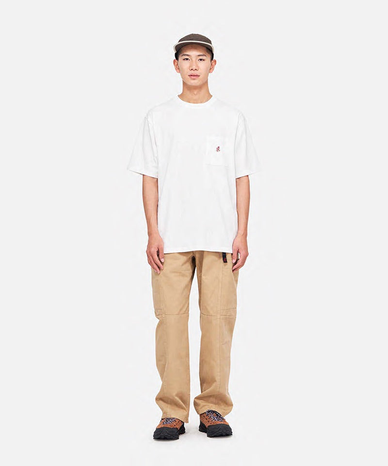 Model wearing a white Gramicci One Point Tee with a small running man graphic and khaki pants on a light-tone background.