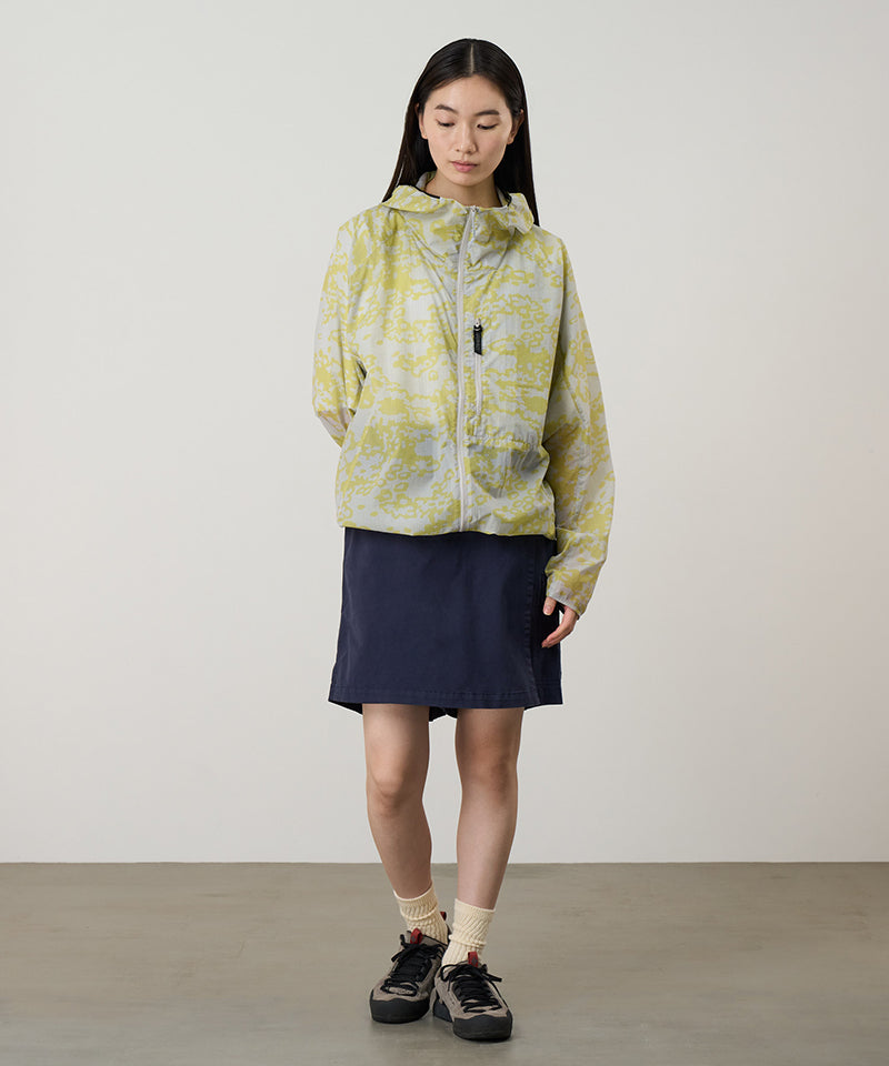 Model wearing a Gramicci G-Skort in the color double navy and a yellow patterned jacket on a light-tone background.