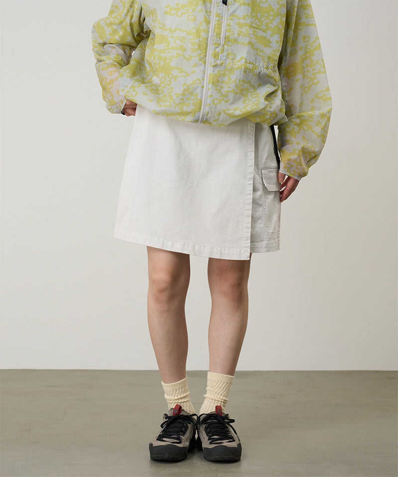 Model wearing a Gramicci G-Skort in the color shell white and a yellow patterned jacket on a light-tone background.
