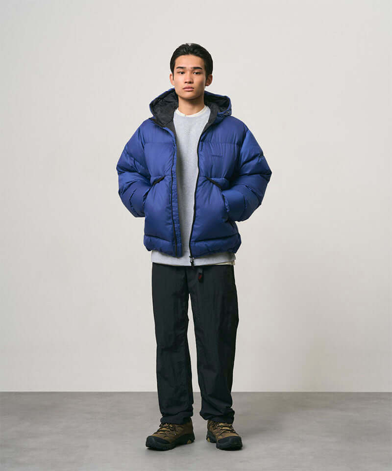 Model wearing black Nylon Gramicci Pants and a blue jacket on a light-tone background.