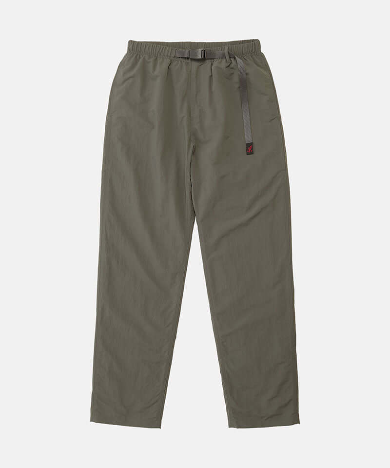Burnt olive colored Nylon Gramicci Pants with a belt against a light-tone background.
