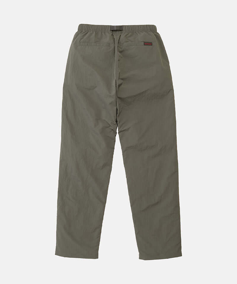 Back view of burnt olive colored Nylon Gramicci Pants on a light-tone background.