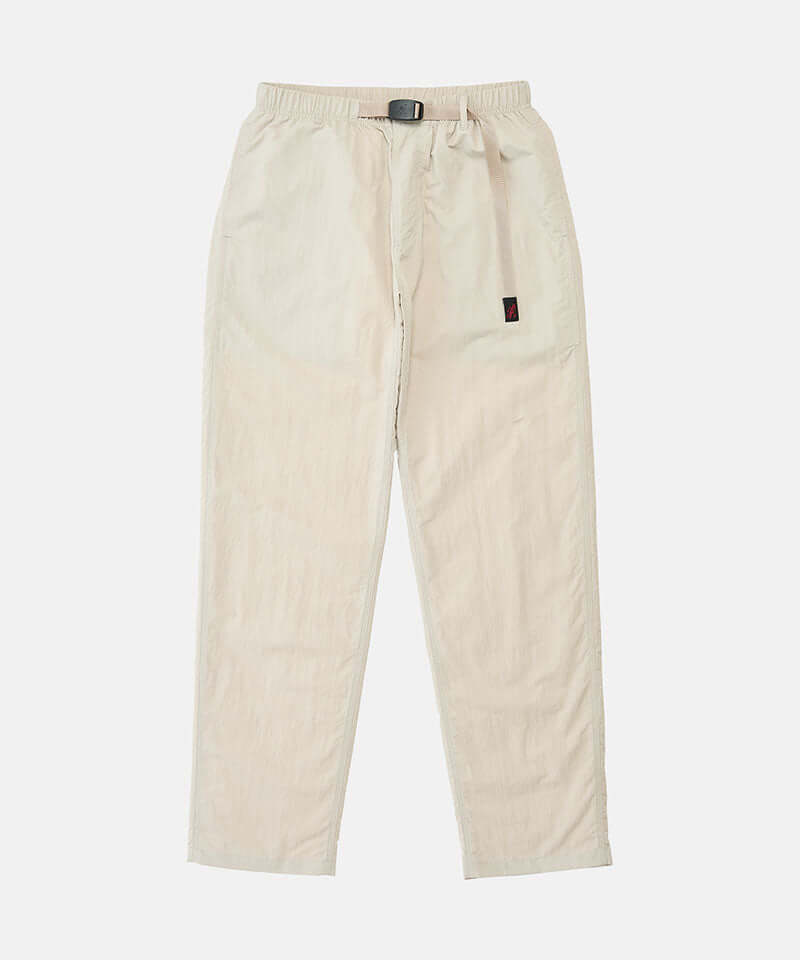 Stone colored Nylon Gramicci Pants with a belt against a light-tone background.