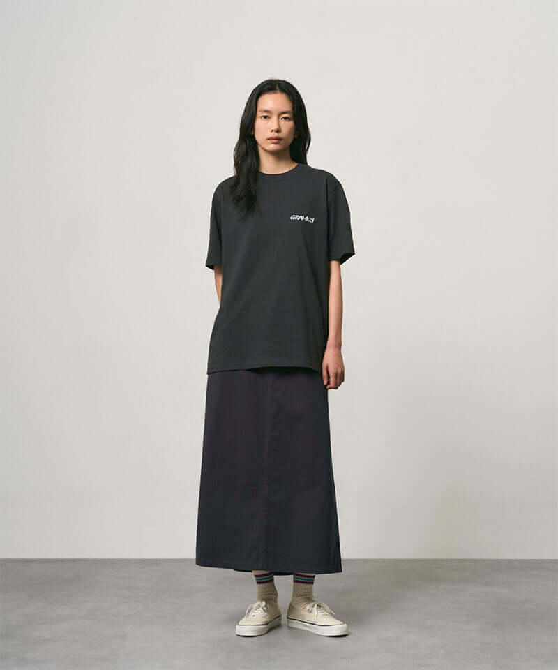 Model wearing a vintage black Gramicci Bass Tee and black skirt on a light-tone background.