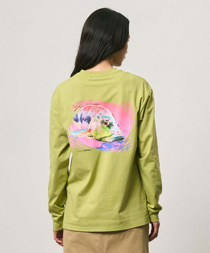 Back view of a model wearing a Gramicci sweet pea colored Bass Long-Sleeve Tee with a graphic against a light-tone background.