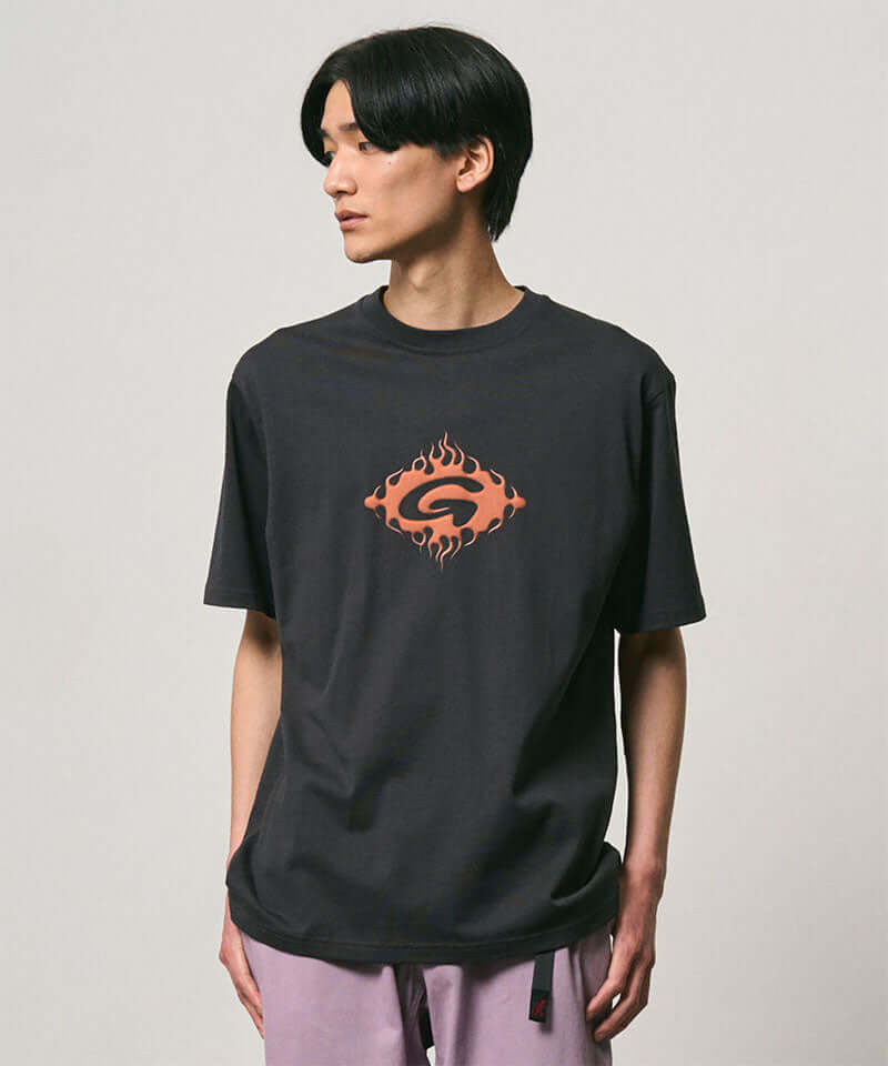 Model wearing a Gramicci vintage black Flames Tee with a graphic against a light-tone background.