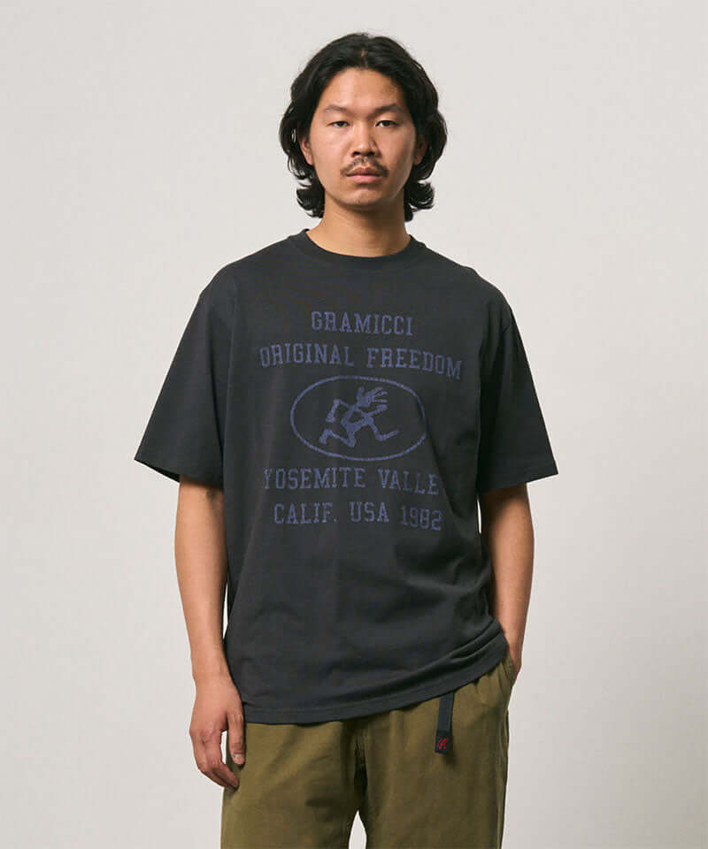 Model wearing a Gramicci vintage black Yosemite Valley Tee with a graphic against a light-tone background.