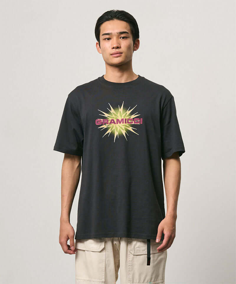 Model wearing a Gramicci vintage black Starburst Tee with a graphic against a light-tone background.