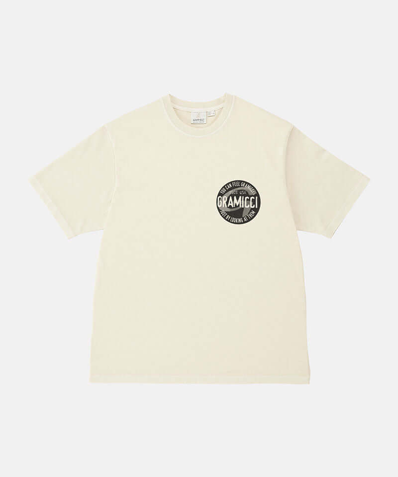 Gramicci natural pigment colored Icon Tee Pigment Dyed with a graphic against a light-tone background.