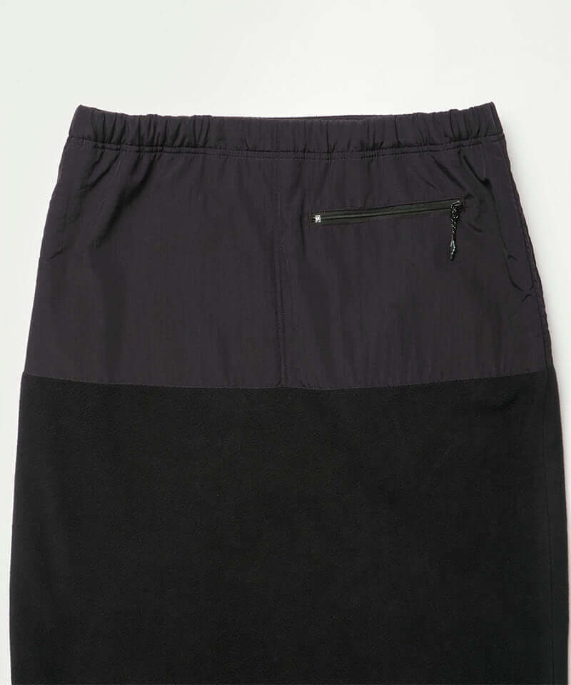 Back view close-up of a black Gramicci Thermal Fleece Skirt against a light-tone background.