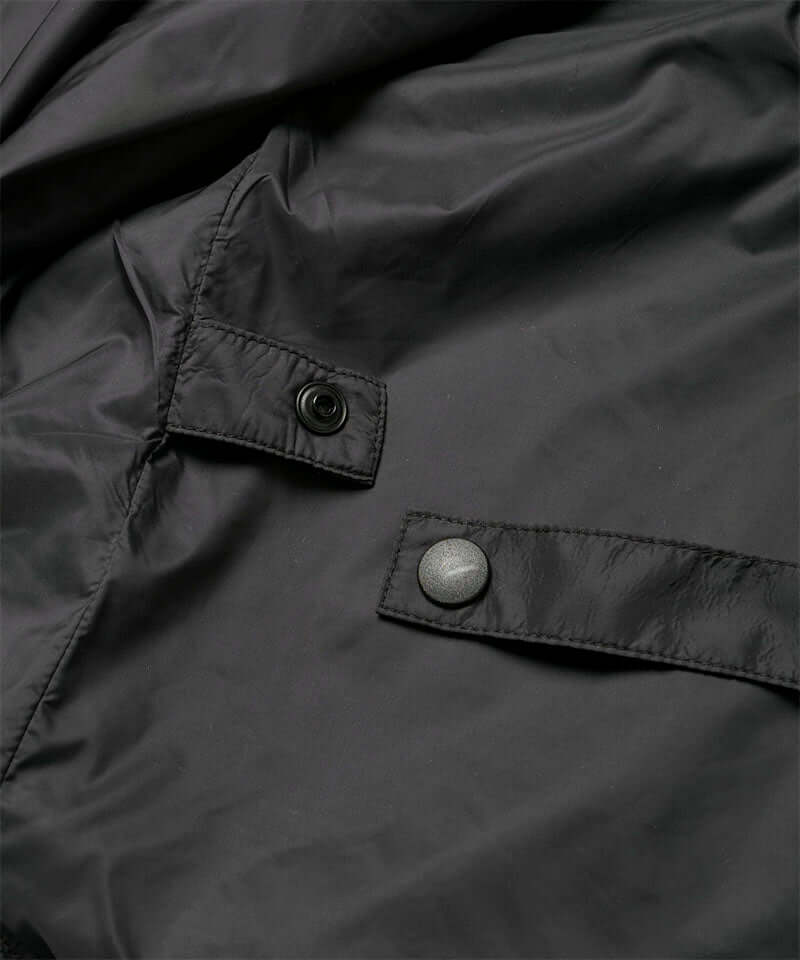 Close-up view of a black Gramicci Thermal Fleece Skirt against a light-tone background.