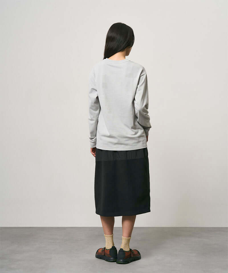 Model wearing a black Gramicci Thermal Fleece Skirt and a grey sweatshirt on a light-tone background.
