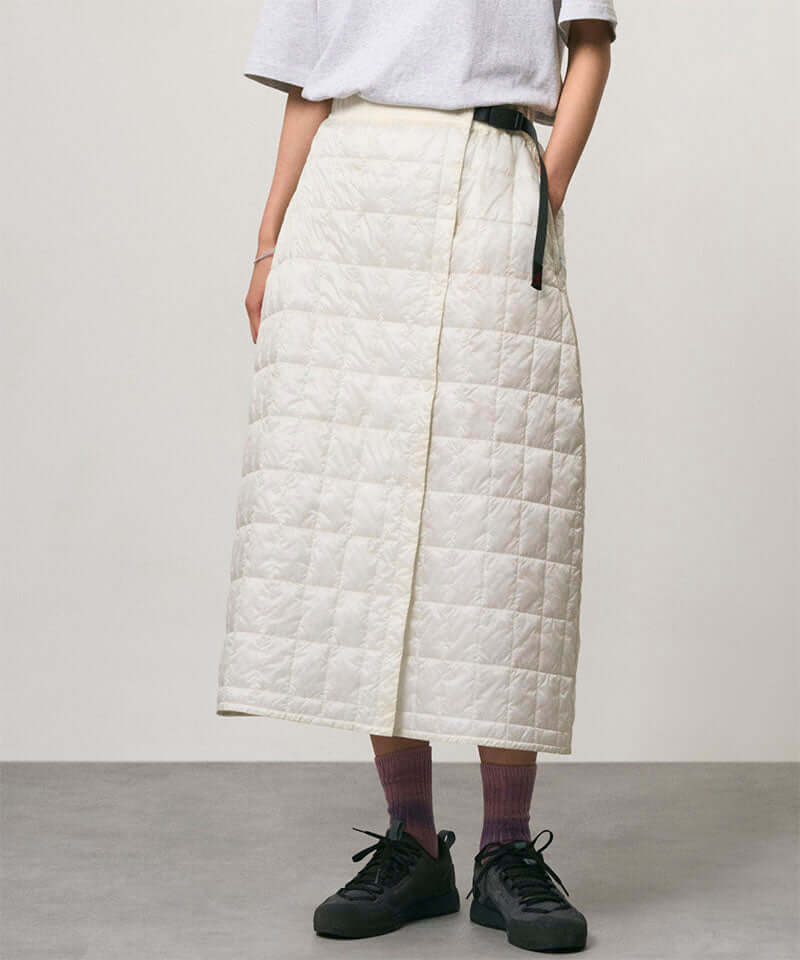 Model wearing a frost colored Gramicci G-Zero Primaloft Skirt and a white shirt on a light-tone background.