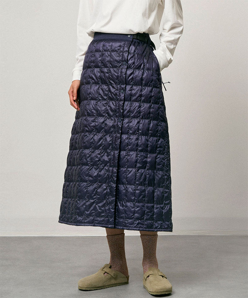 Model wearing a indigo Gramicci G-Zero Primaloft Skirt and a white shirt on a light-tone background.