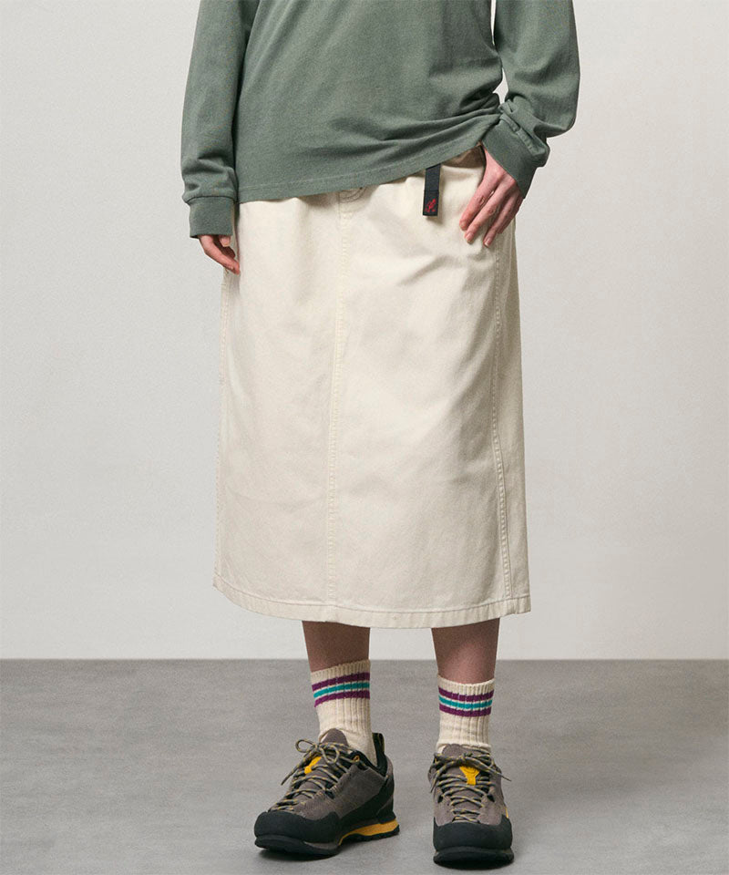 Model wearing a bone colored Gramicci Denim Carpenter Skirt and a olive shirt on a light-tone background.