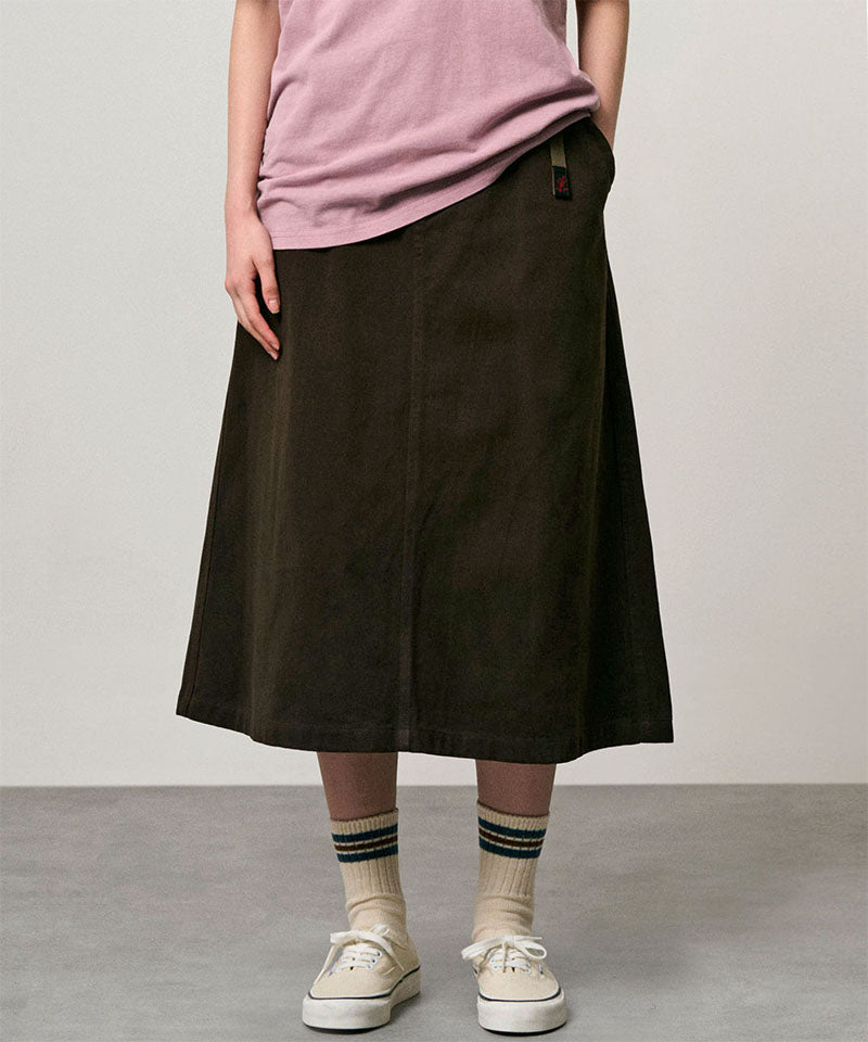 Model wearing a coffee colored Gramicci Venture Skirt and a pink shirt on a light-tone background.