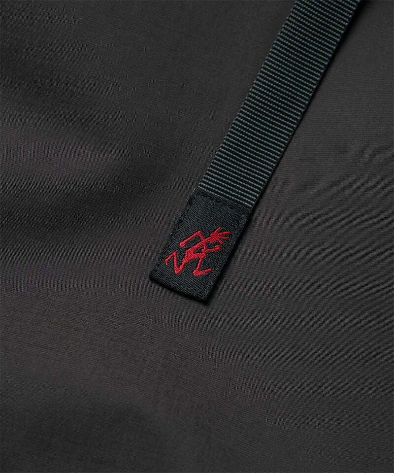 Close-up view of a black women's Gramicci WR Convertible Skirt belt with logo.