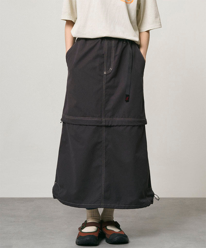 Model wearing a black women's Gramicci WR Convertible Skirt and a creme colored shirt on a light-tone background.