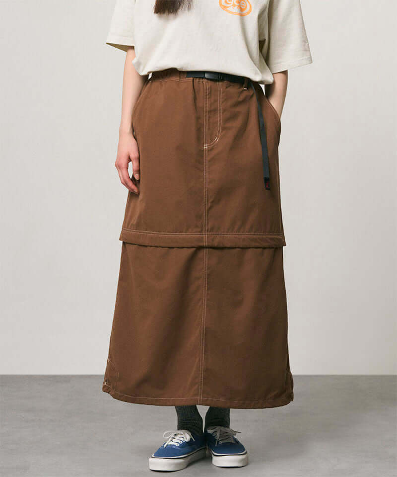 Model wearing a deep brown women's Gramicci WR Convertible Skirt and a creme colored shirt on a light-tone background.