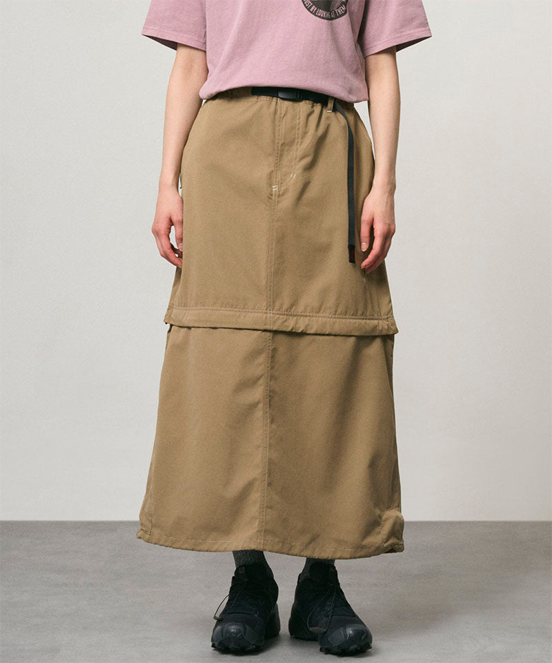 Model wearing a khaki colored women's Gramicci WR Convertible Skirt and a dusty pink shirt on a light-tone background.