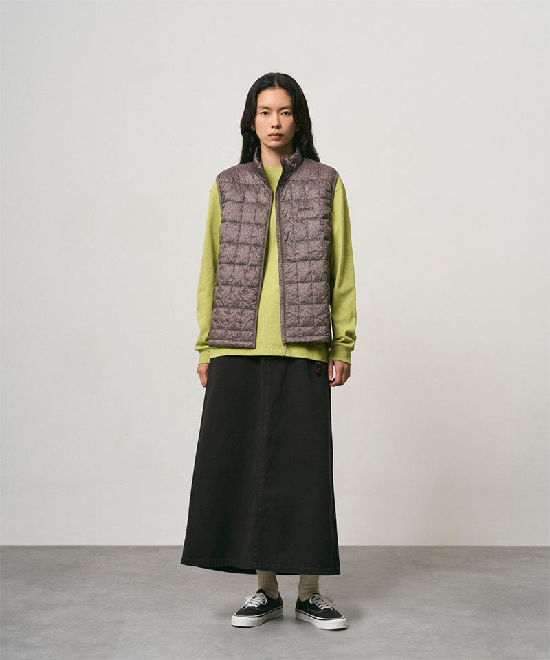 Model wearing a black Gramicci 5-Pocket Skirt and a brown vest on a light-tone background.