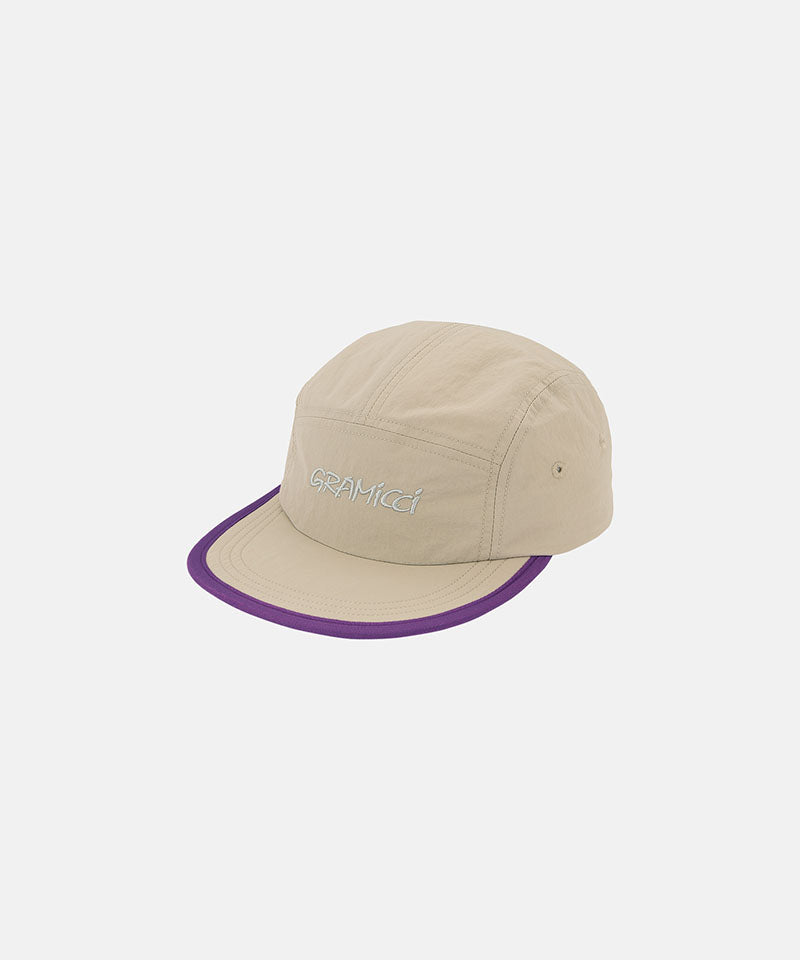 Milk tea beige colored Nylon Gramicci Cap with a purple brim and logo on a light tone background.