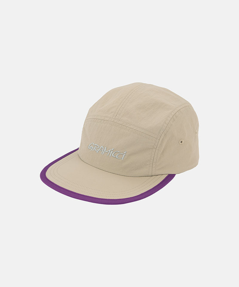 Milk tea beige colored Nylon Gramicci Cap with a purple brim and logo on a light tone background.