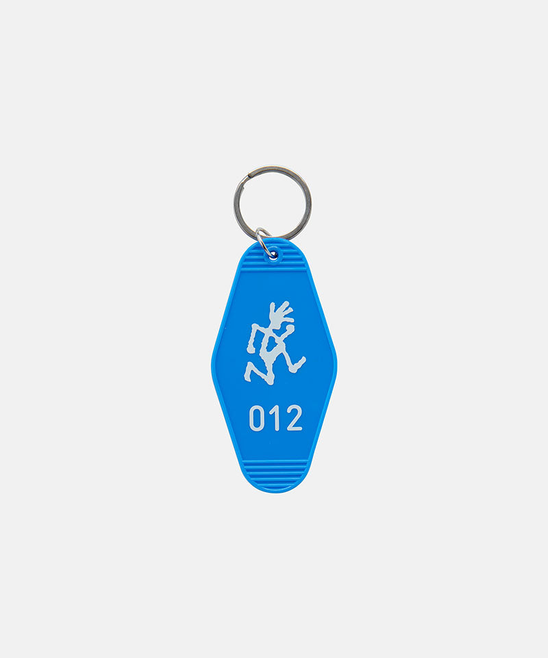 Blue Gramicci Hotel Keychain against a light-tone background.