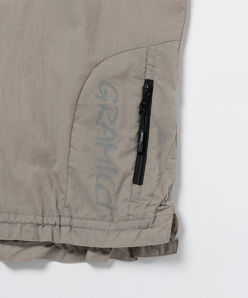 Close-up view of a Gramicci Ultra-Light Packable Jacket pocket in concrete colored on a light-tone background.
