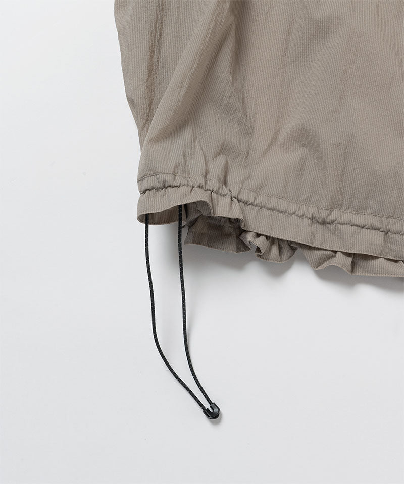 Gramicci concrete colored Ultra-Light Packable Jacket hem with drawstring detail against a light-tone background.