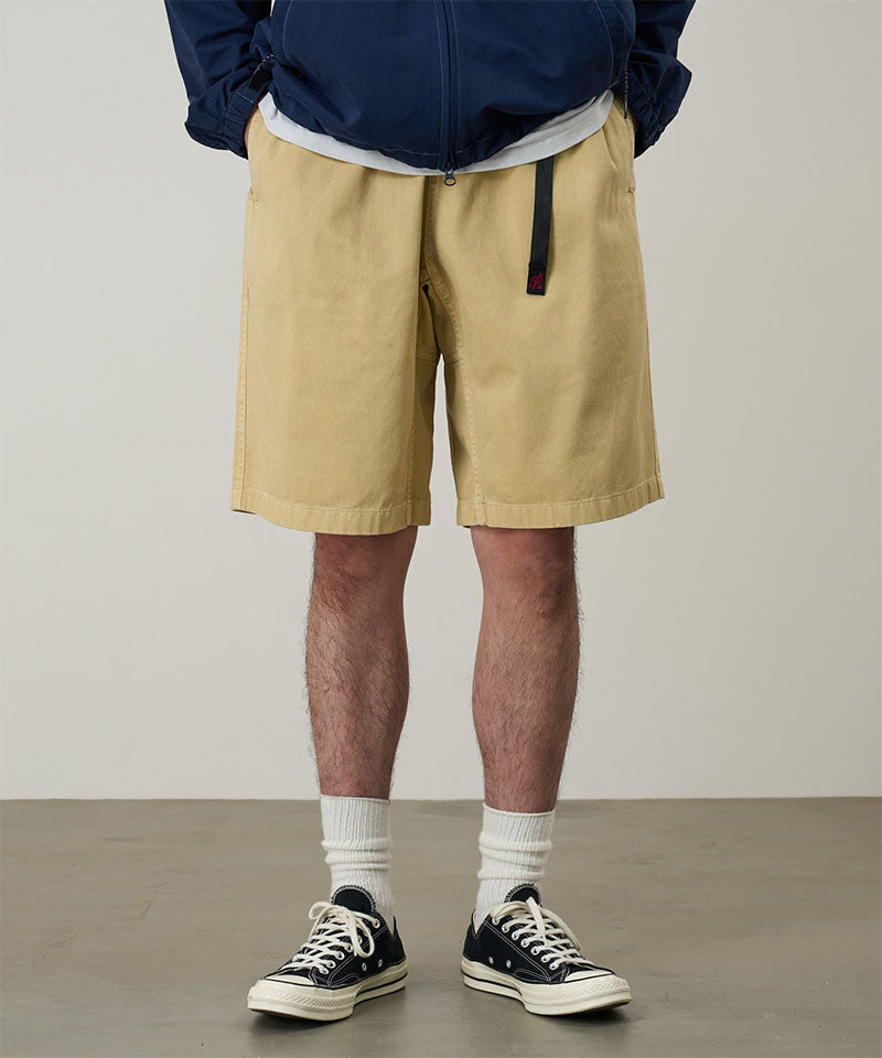 Model wearing a Gramicci Natural Dyed Jam Short in the color chino on a light-tone background.