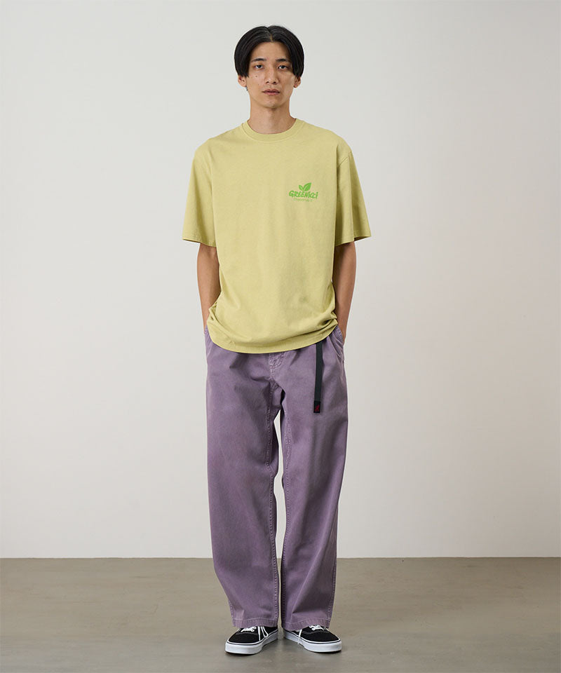Model wearing a purple Gramicci Natural Dyed Gramicci Pant Straight Fit and yellow shirt on a light-tone background.