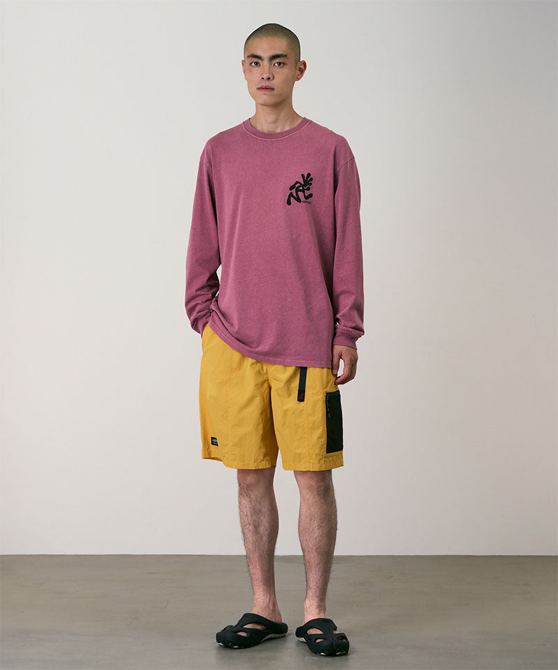 Person wearing a red long-sleeve shirt and yellow shorts against a plain background