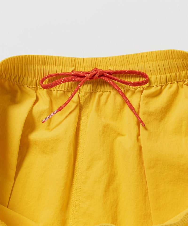 Yellow shorts with a red drawstring on a light gray background