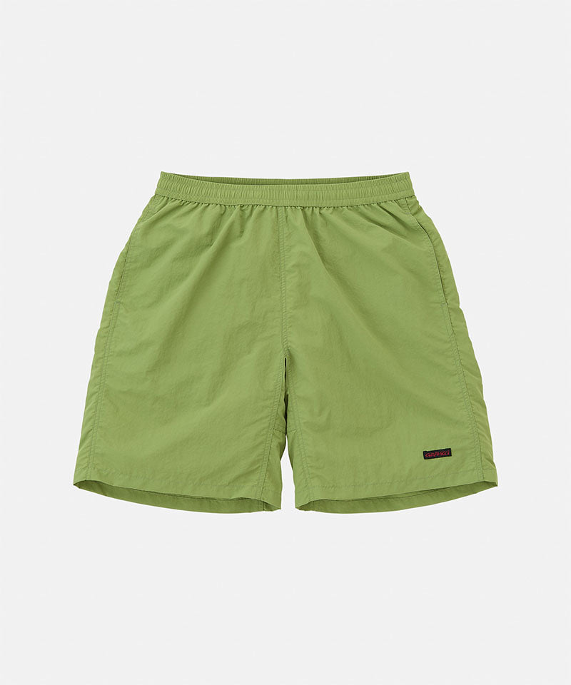 Green shorts with a brand label on a light gray background