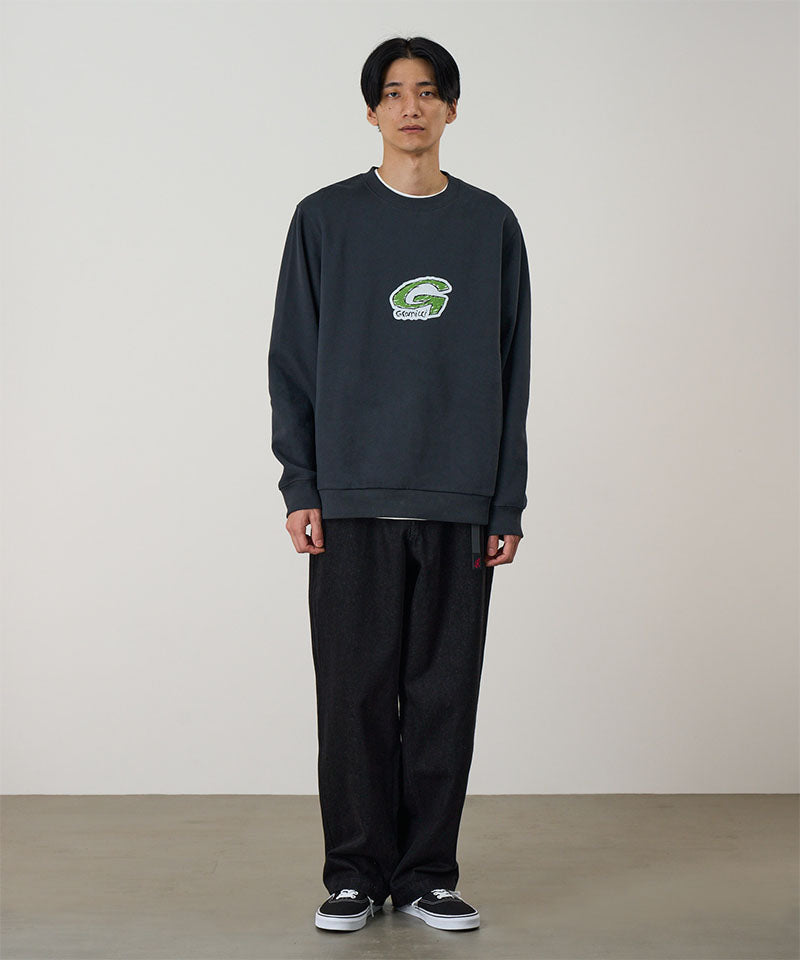 Person wearing a dark blue sweatshirt with a logo on a plain background