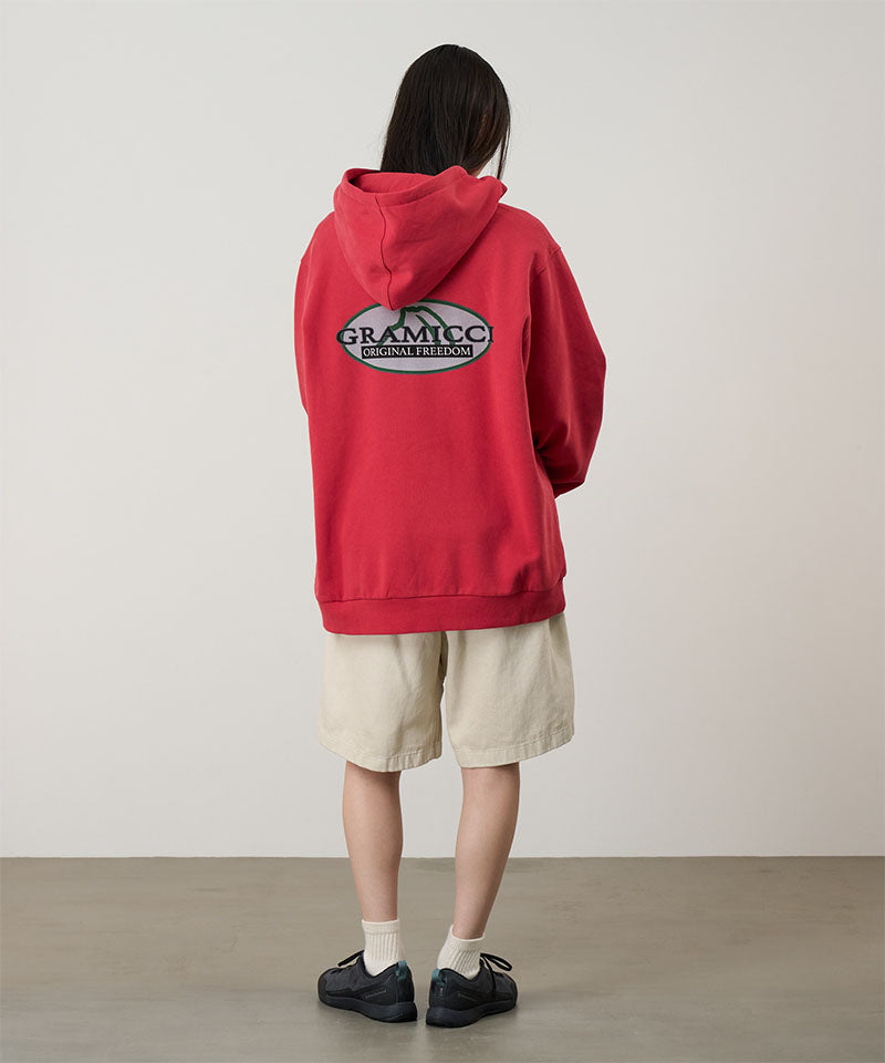 Person wearing a red hoodie with a logo on the back, standing against a plain background