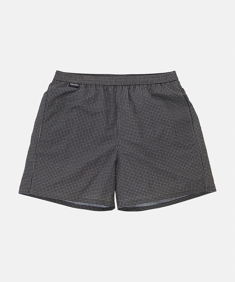 Front view of black Gramicci Grid Swim Shorts against a light tone background.