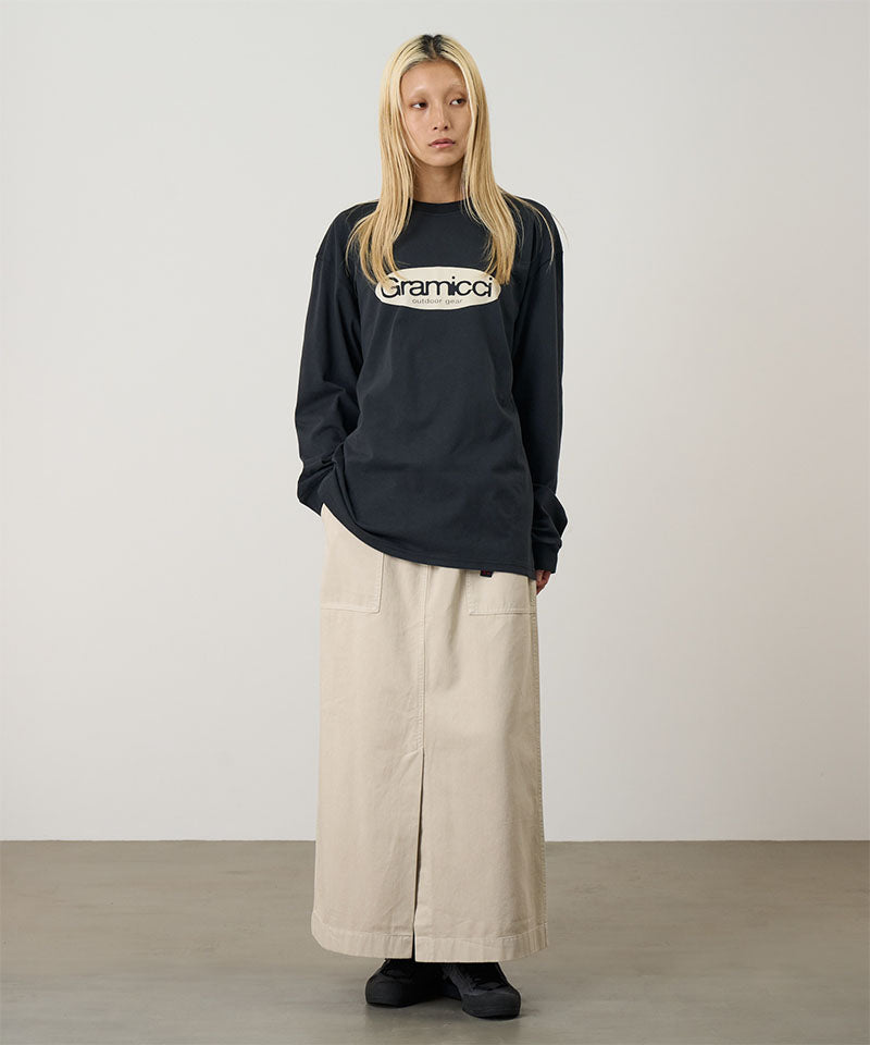 Model wearing a vintage black Gramicci Gramicci Outdoor Gear L/S Tee with a light beige graphic and dark pants on a light-tone background.