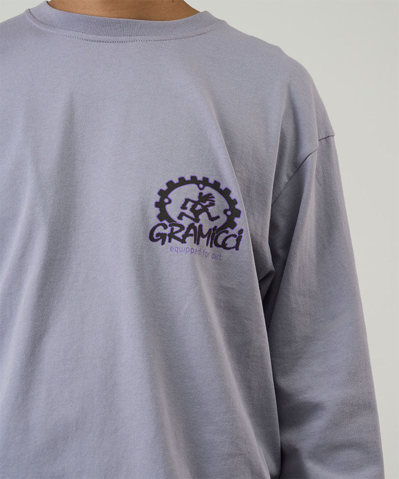 Model wearing a Gramicci lavender Equipped For Dirt L/S Tee with a Gramicci gear graphic graphic against a light tone background.