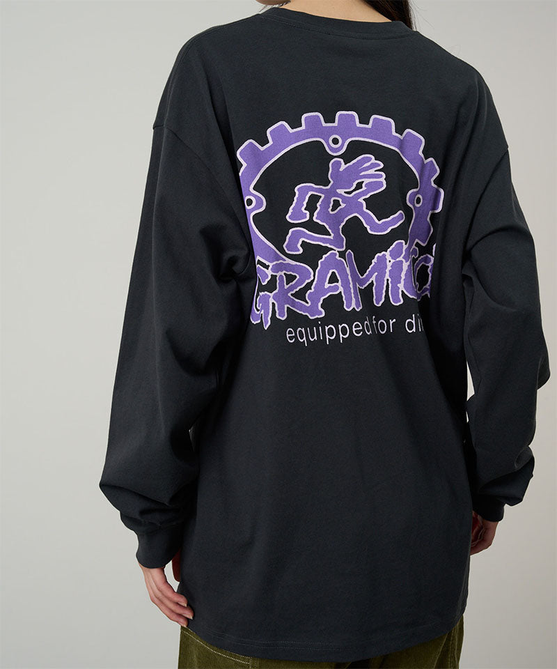 Back view of a model wearing a Gramicci vintage black Equipped For Dirt L/S Tee with a Gramicci gear graphic graphic against a light tone background.