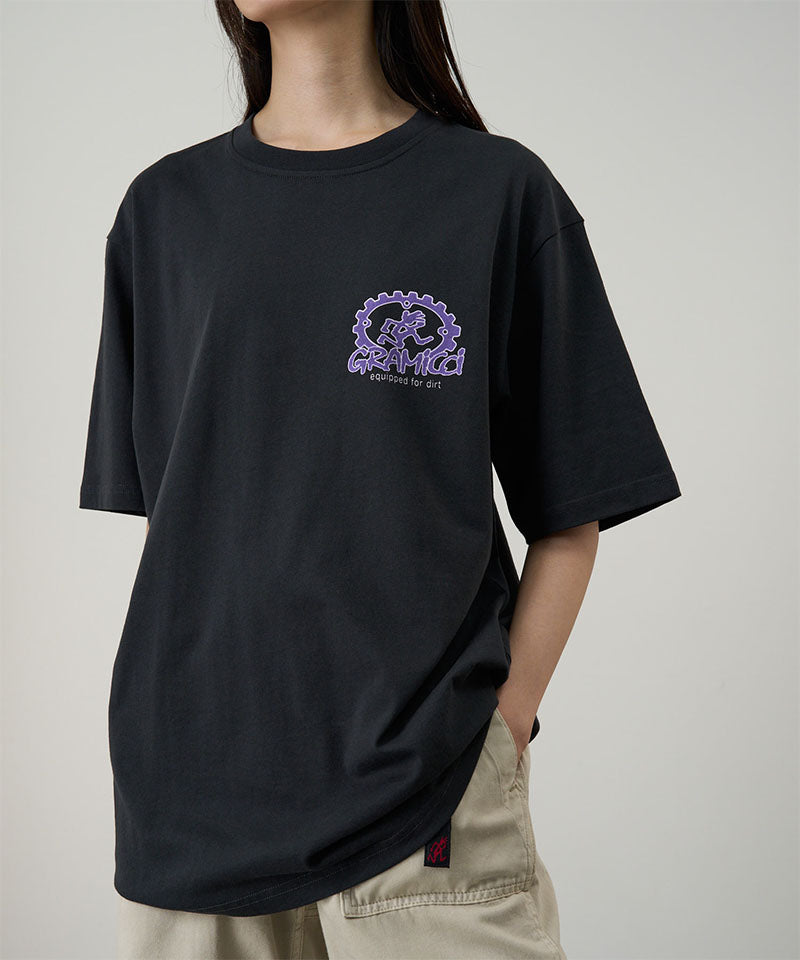 Model wearing a Gramicci vintage black Equipped For Dirt Tee with a purple graphic against a light-tone background.