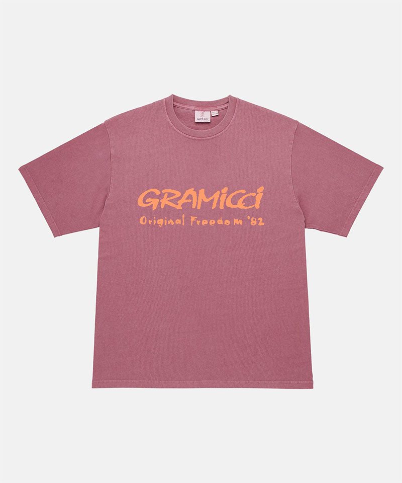 Gramicci red pigment Freedom Tee Pigment Dyed with mango colored graphic against a light tone background.
