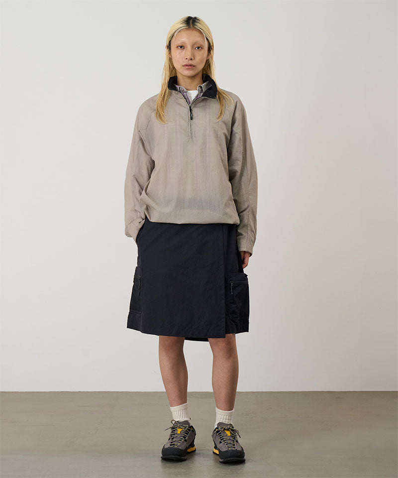 Model wearing black Gramicci Guide Skort and a beige jacket on a light-tone background.