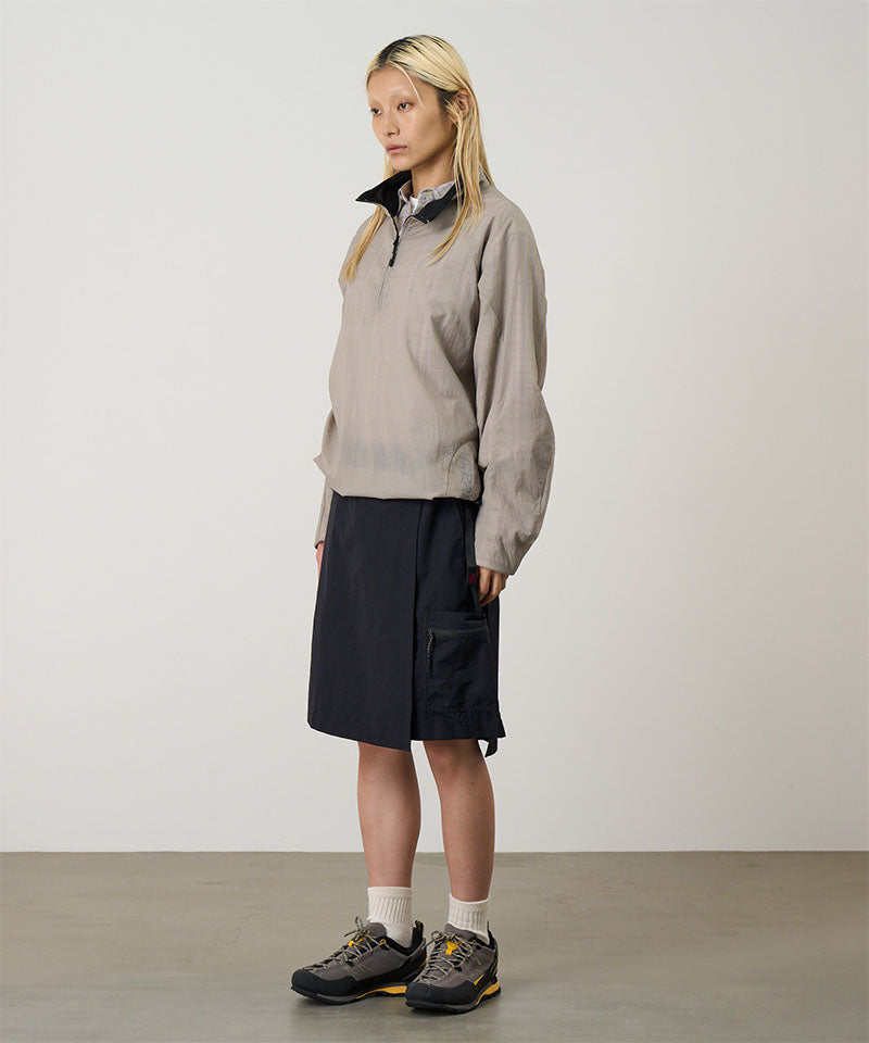 Model wearing black Gramicci Guide Skort and a beige jacket on a light-tone background.