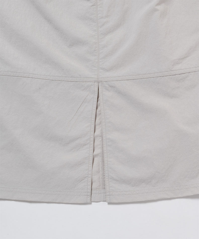 Close-up of a light gray skirt with a white background