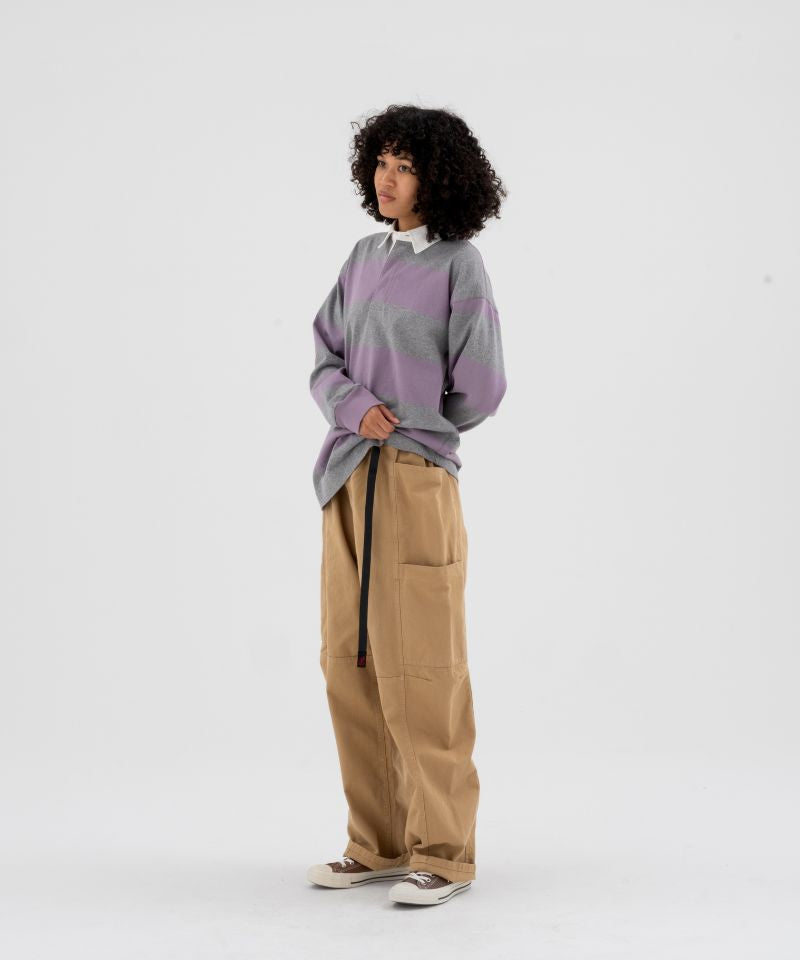 Model wearing beige Gramicci Voyager Pants and a lavender and grey stripped Gramicci Langdon Rugby Long-Sleeve shirt on a light-tone background.
